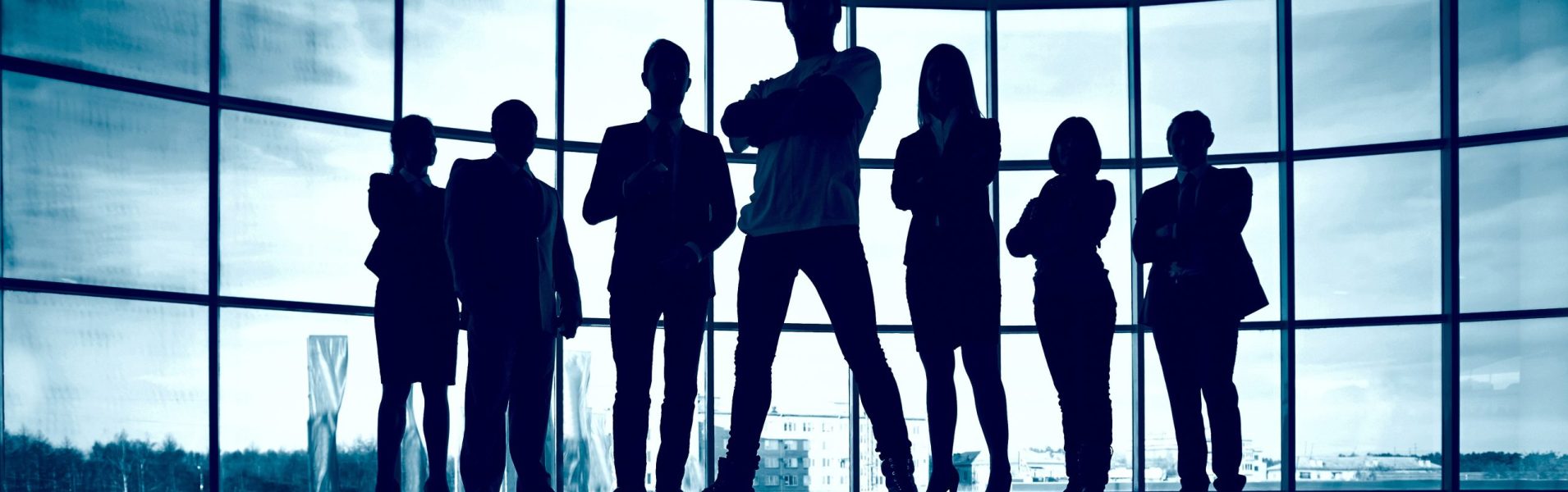 Business team standing against window with leader in front